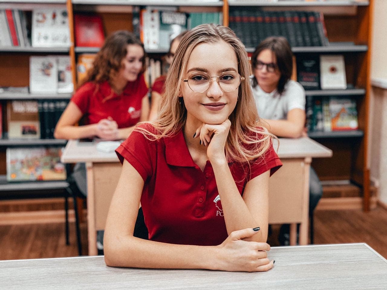 Учениця Centrum Polonijne за партою в класі з полицями польських книжок